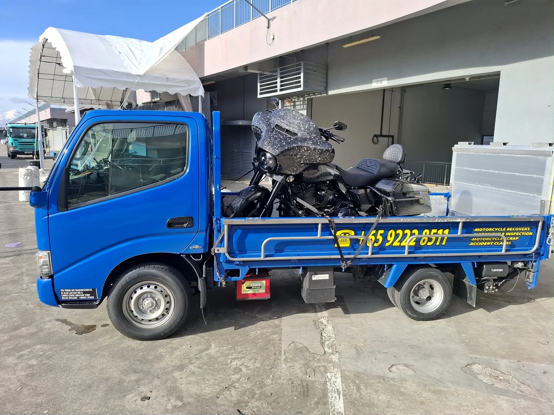 Siva Towing blue motorcycle recovery lorry carrying a motorcycle in Singapore