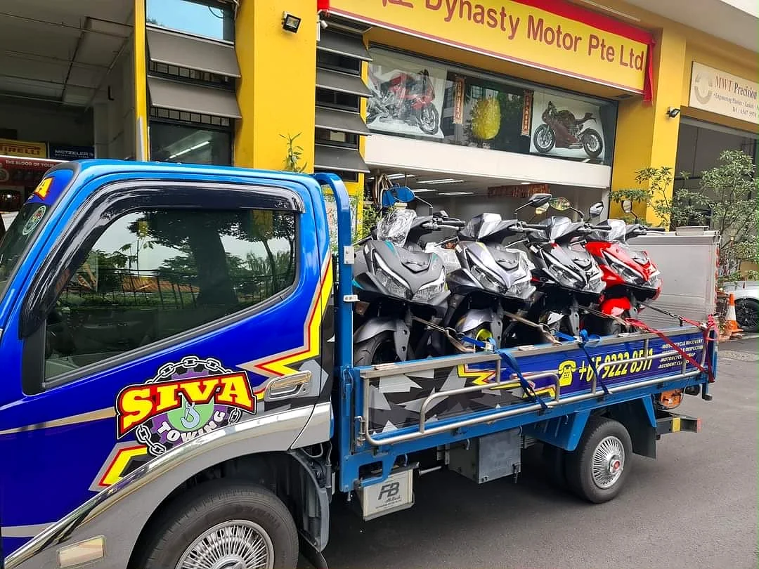 Siva Towing lorry collecting motorcycles outside a Singapore workshop